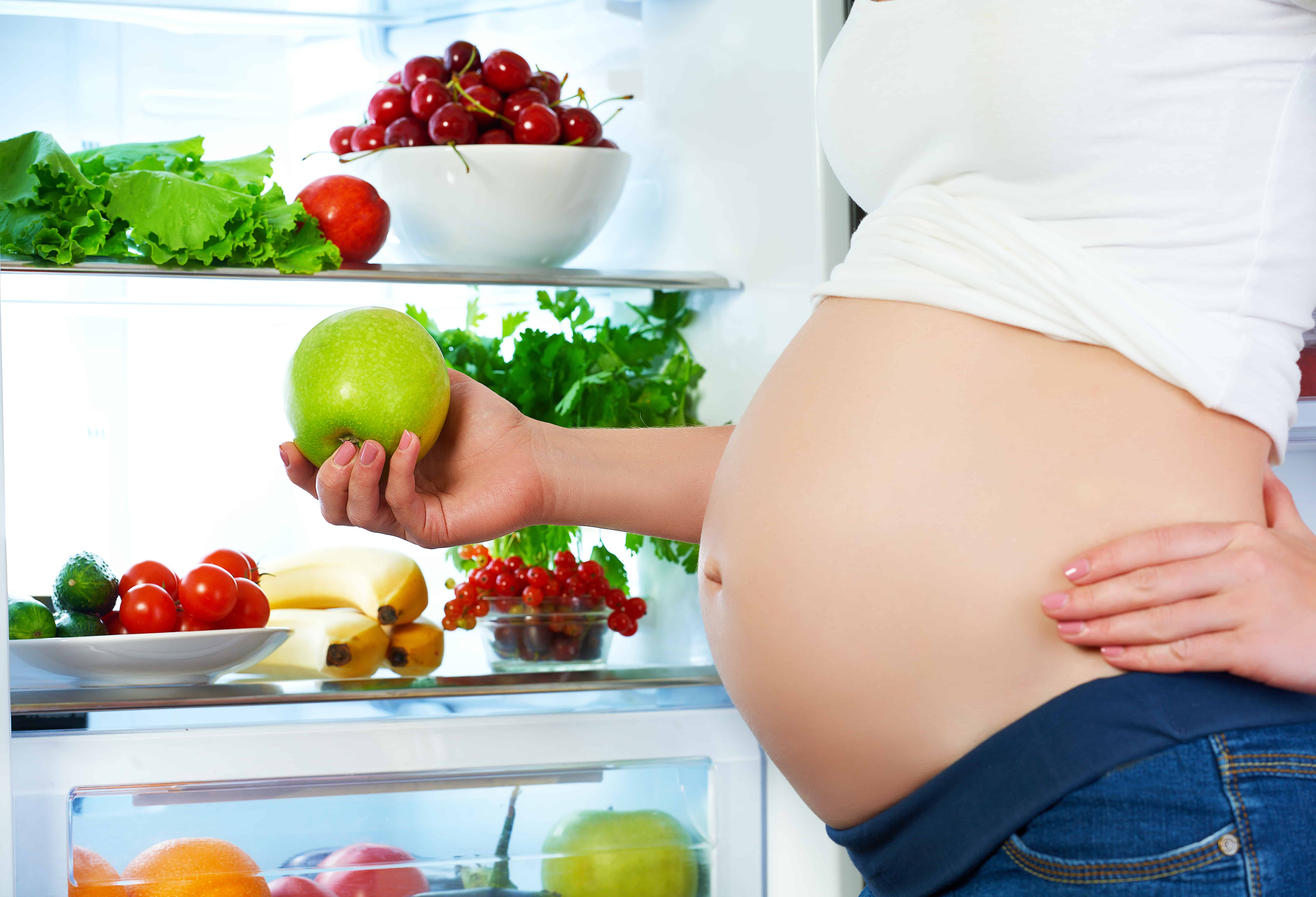 Image of pregnant woman holding an apple